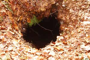 A small hole in the ground with a large cavity below