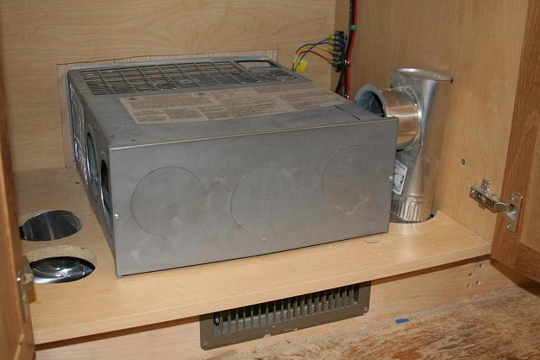 The heater hot air furnace tucks into this kitchen cabinet.