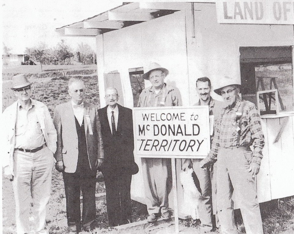Photograph taken in 1961 of two officials and others of the McDonald Territory