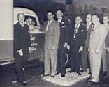 GATHERED IN INTERNATIONAL HARVESTER's New York showrooms prior to departure for Africa. Cmdr. Gatti receives congratulations from James Melton (center in striped suit), star of Harvester's Sunday afternoon radio program, other IH-officials, as well as officers of other firms participating in readying the eleventh venture of the veteran African explorer. Seated inside the truck is Weldon King, Gatti's chief aid in charge of color photography.