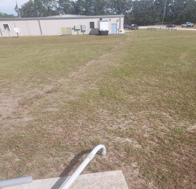 A white pipe in a field

Description automatically generated