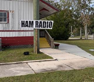 A sign on a pole in front of a building

Description automatically generated