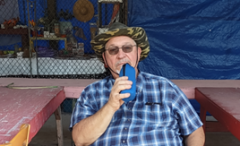 A person in a hat holding a blue flask

AI-generated content may be incorrect.