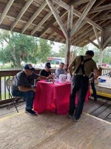 A group of men sitting at a table

Description automatically generated