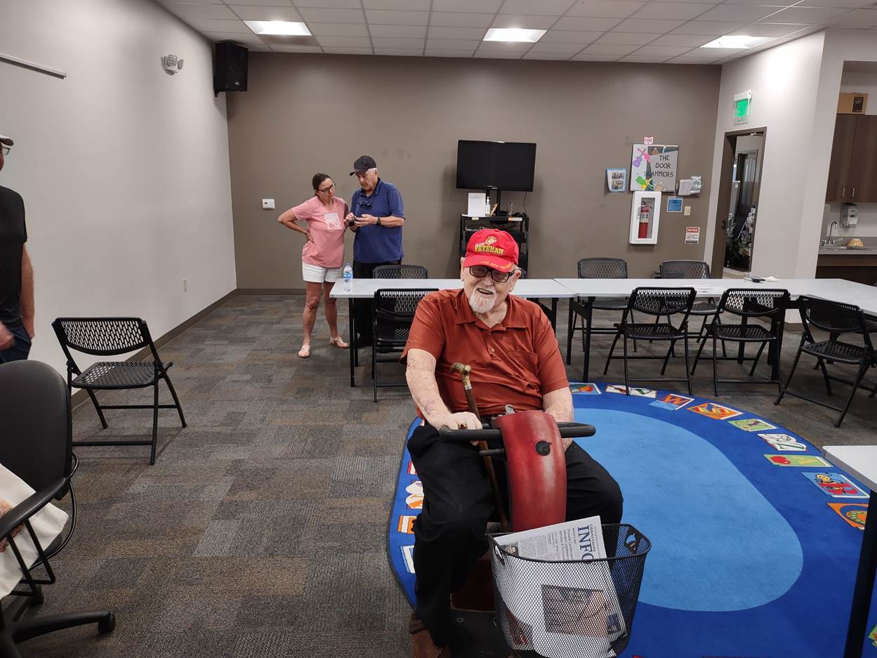 A person in a red hat sitting on a scooter

Description automatically generated